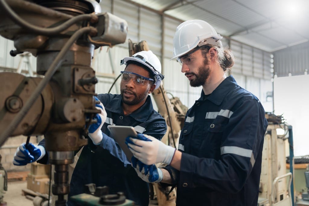 Profesionales con protecciones trabajando sobre máquina