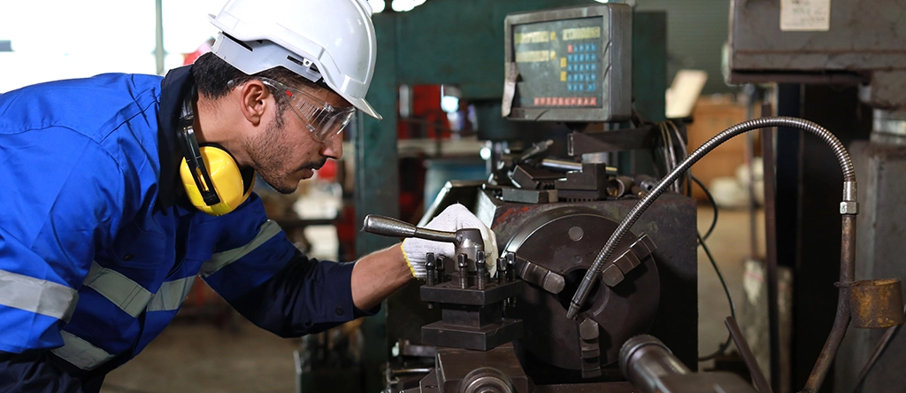 Obrero realizando tareas de mantenimiento de maquinaria industrial